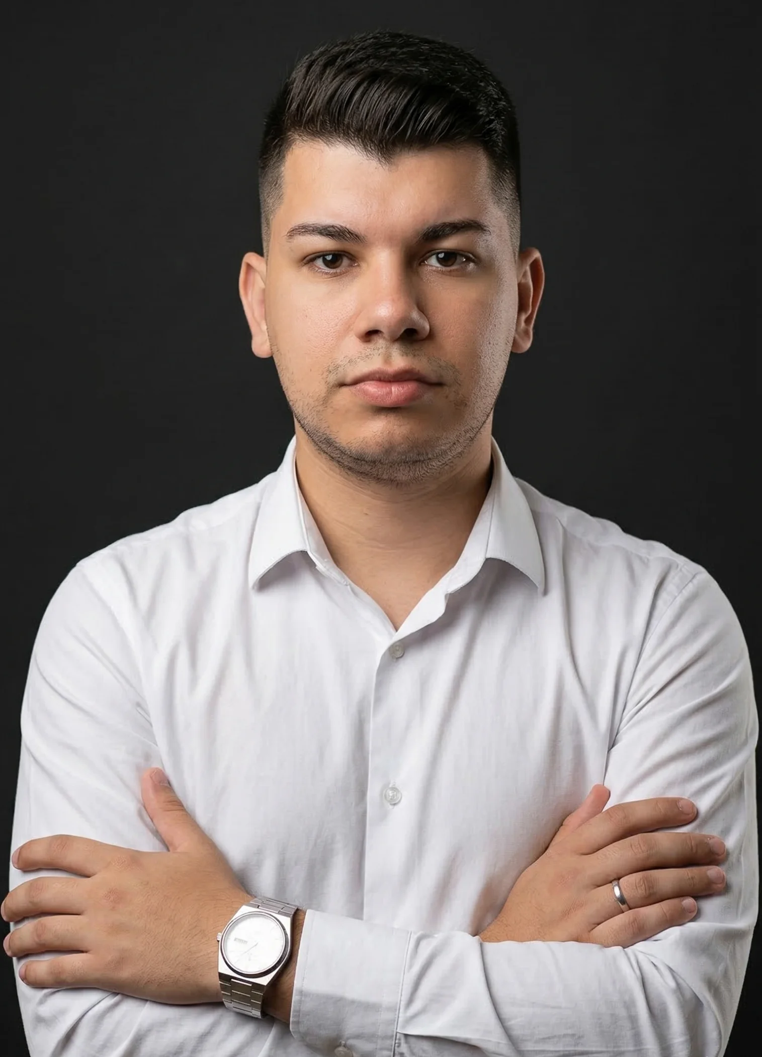 Foto de Endrew Fernandes sob um fundo escuro, de braços cruzados.